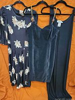 Front view of all three dresses on hangers