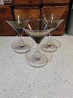 Three smoky gray martini glasses front view