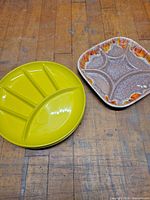 Stacked yellow melamine plate beside square ceramic platter showing size and color contrast