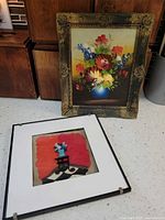 Both framed artworks standing on countertop