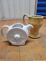 Both pottery pieces side by side on floor