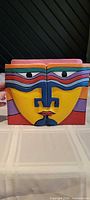 Front view of paired wooden bookends showing complete painted face design