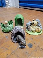 Four assembled figurine groups on wooden floor