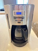 Front view showing stainless front, digital display, glass carafe