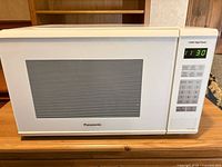 Front view of Panasonic white microwave showing control panel and display