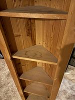 Front view of tall pine corner shelf showing six triangular shelves