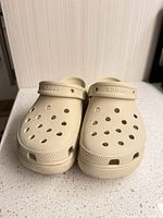 Front view of both light beige Crocs clogs showing perforations and straps