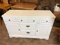 front view of white buffet showing drawers and cabinet doors