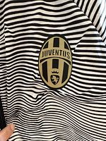 Close-up of embroidered Juventus crest on striped fabric