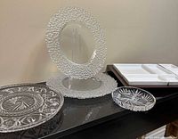 overview showing crystal cake plate, two charger plates, small cut-glass dish, wood tray with six ceramic dishes