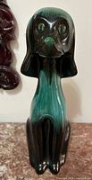 Front view of Blue Mountain Pottery green-black drip glaze dog figurine
