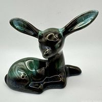 Reclining fawn pottery figurine showing overall form and glaze colors