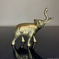 Side view brass elephant figurine standing trunk up
