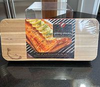 Shrink-wrapped pack of six cedar grilling planks showing size and label