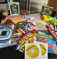 Overhead view showing all books, read-along CDs, dart blaster, Tetris game, wooden toys, surprise packs