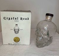 Front view of skull bottle beside front of original box