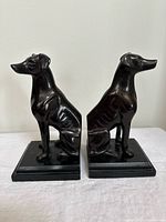 Two black dog bookends facing opposite directions on square bases