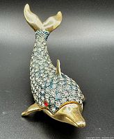 Overall view of rhinestone-encrusted dolphin trinket box showing hinge and magnet closure