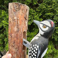 Close-up of woodpecker figure mounted on log section
