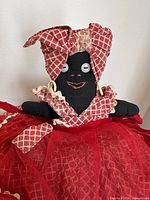 Front view of doll showing dress, headscarf, earrings, face details