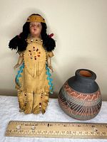Full view of doll and vase with ruler for scale