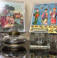 Two glass inkwells (round with brass lid, square with glass lid) front, two boxed Asian scene note card sets in background