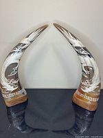 Both curved horn sculptures standing on bases, full view