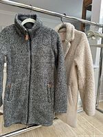 Front view of both jackets hanging on rack