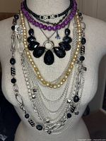 Front view showing all eight layered necklaces on display bust