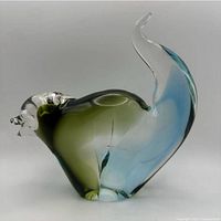 Side view of hand-blown multicolor glass animal figurine showing tail and color gradient