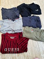 All six T-shirts laid out showing colors and logos