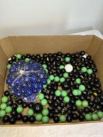 Top view of full box showing black, green and bagged blue marbles