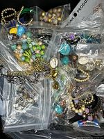 Overview of multiple zipper bags containing assorted costume jewelry and beads