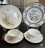 Group shot: two decorative plates, two teacups, two saucers