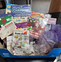 Overview of box containing transfer packs, iron-on kit, beads and charms