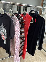 Front view of all five garments hanging on rack