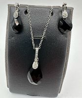 Necklace and matching earring set displayed on stand