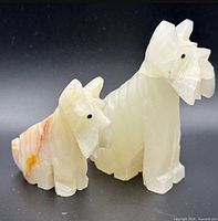 Front view of both onyx/alabaster terrier figurines showing size difference and stone coloration