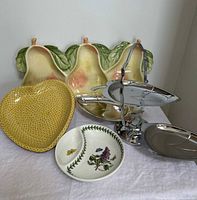 Group shot of all four items: Portmeirion divided bowl, Fitz & Floyd pear platter, chrome 3-tier leaf stand, yellow heart dish