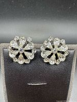Front view of both crystal floral earrings on stand