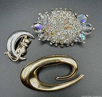 Front view of the three brooches showing design, materials and condition