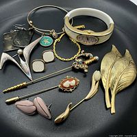 All twelve jewelry pieces arranged on black plate