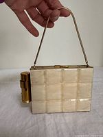 Front view showing mother-of-pearl panels, clasp, lipstick holder, chain handle