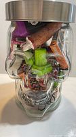 Front view of skull-shaped jar filled with colorful Halloween items