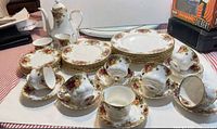Overall view of plates, cups, saucers, coffee pot and creamer