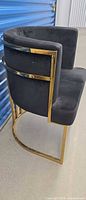 Side view showing curved backrest, velvet upholstery and gold metal frame
