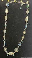 Full view of long Murano glass and crystal necklace laid flat