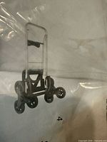 Instruction sheet image showing full view of the Mighty Max Stairglider trolley with handle, frame and four-wheel clusters