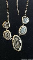Full view of necklace showing five agate slices, silvertone frames and extender chain