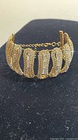 Front view of gold-tone bracelet showing rhinestone pave and adjustable chain
